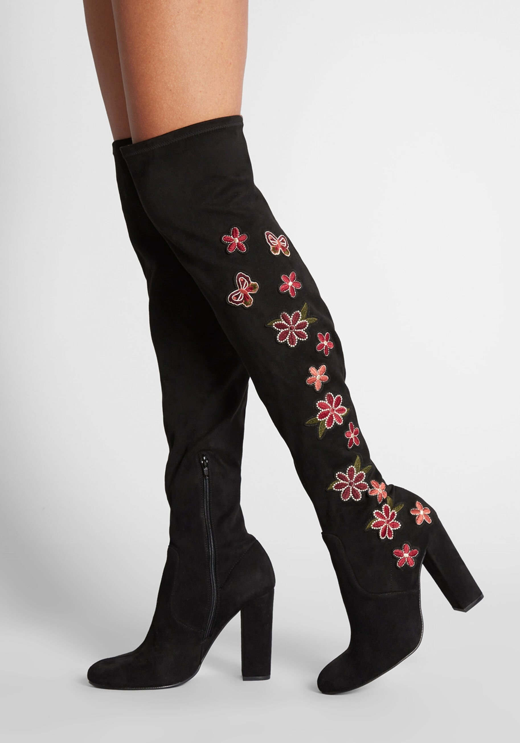 the black over the knee boots with a tall block heel and pink and purple flowers and butterflies along the sides