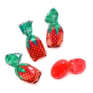 Three candies wrapped to look like strawberries and two candies beside it out of the wraper 
