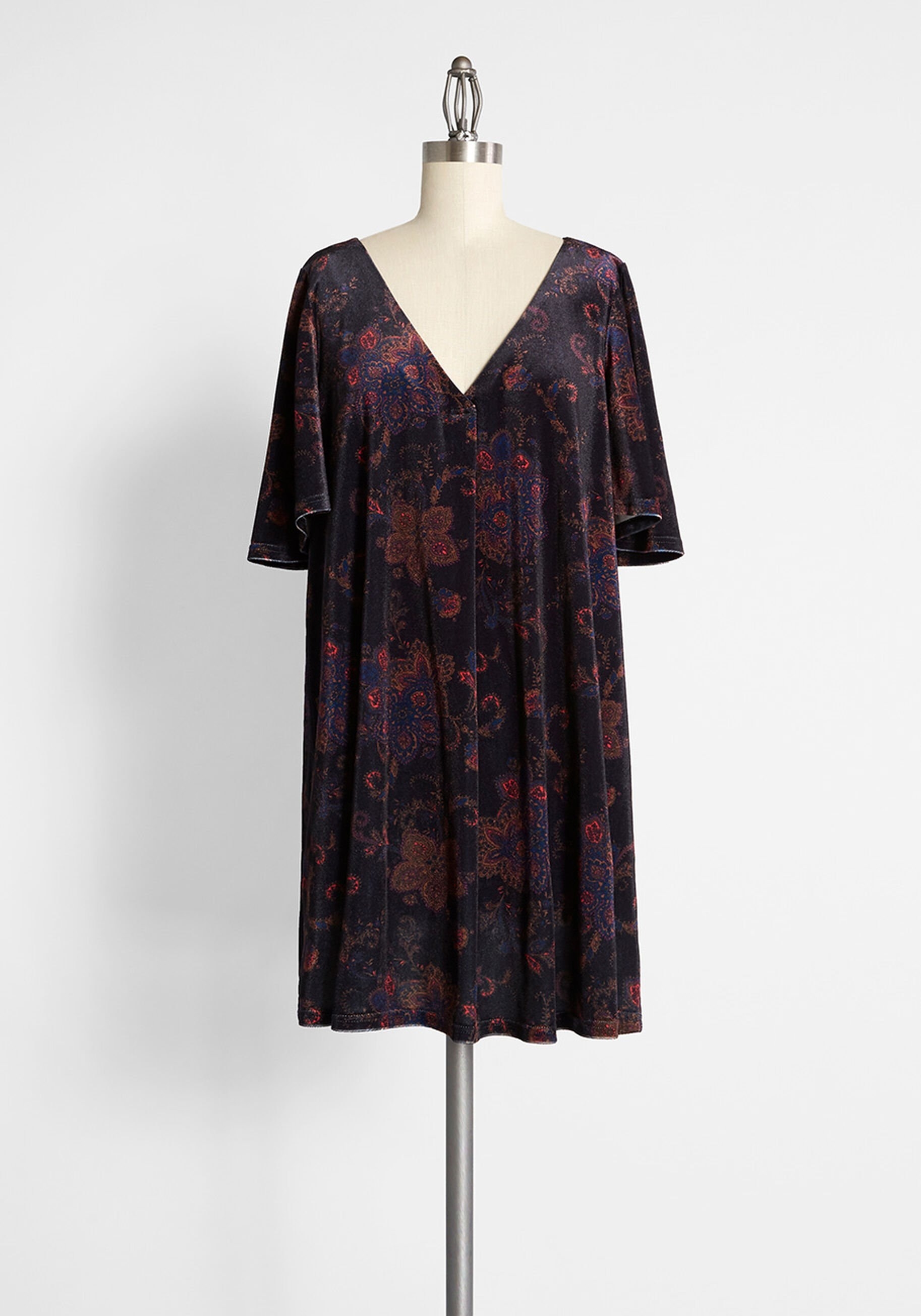 a black dress with an orange, pink, and blue-hued paisley-adorned frock has short, flounce sleeves