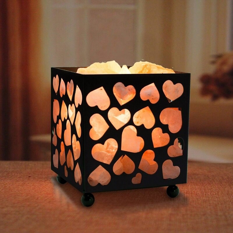 a black metal box with heart-shaped cutouts that's full of small Himalayan salt rocks. they're lit up.