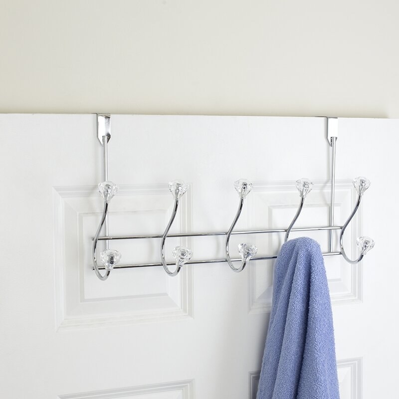 a brack with 10 hooks with clear crystals on the ends of each of them hanging over a door