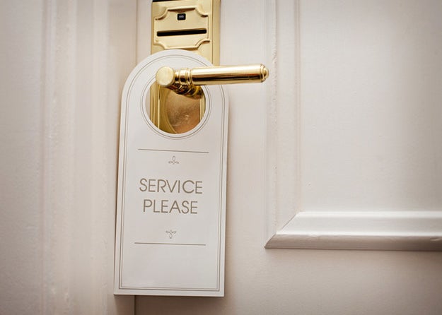 A placard hanging from a door reads "service please"