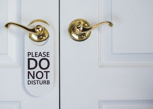 A placard hanging from a door knob reads "Please do not disturb"
