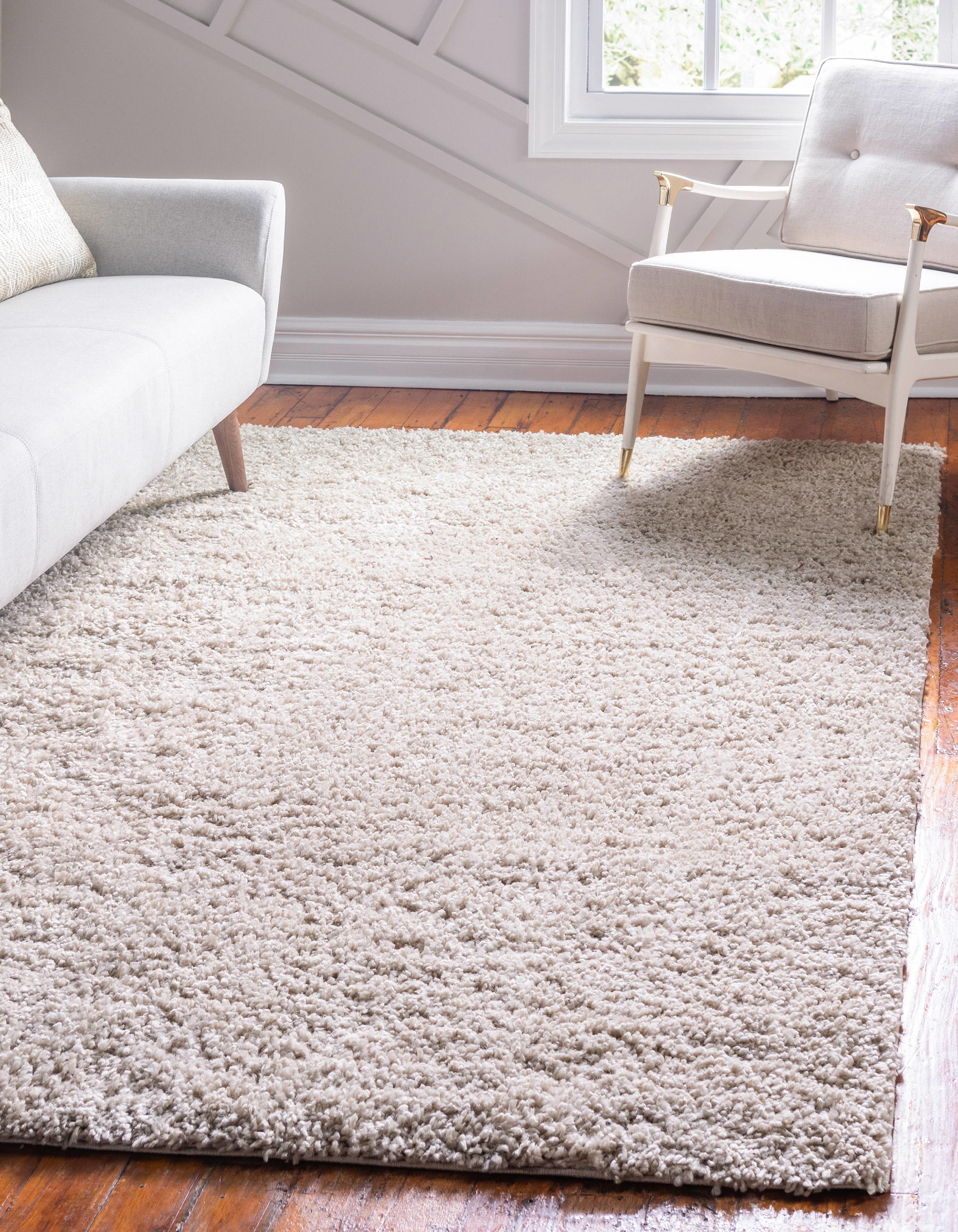 A beige area rug on hardwood floors in a living room