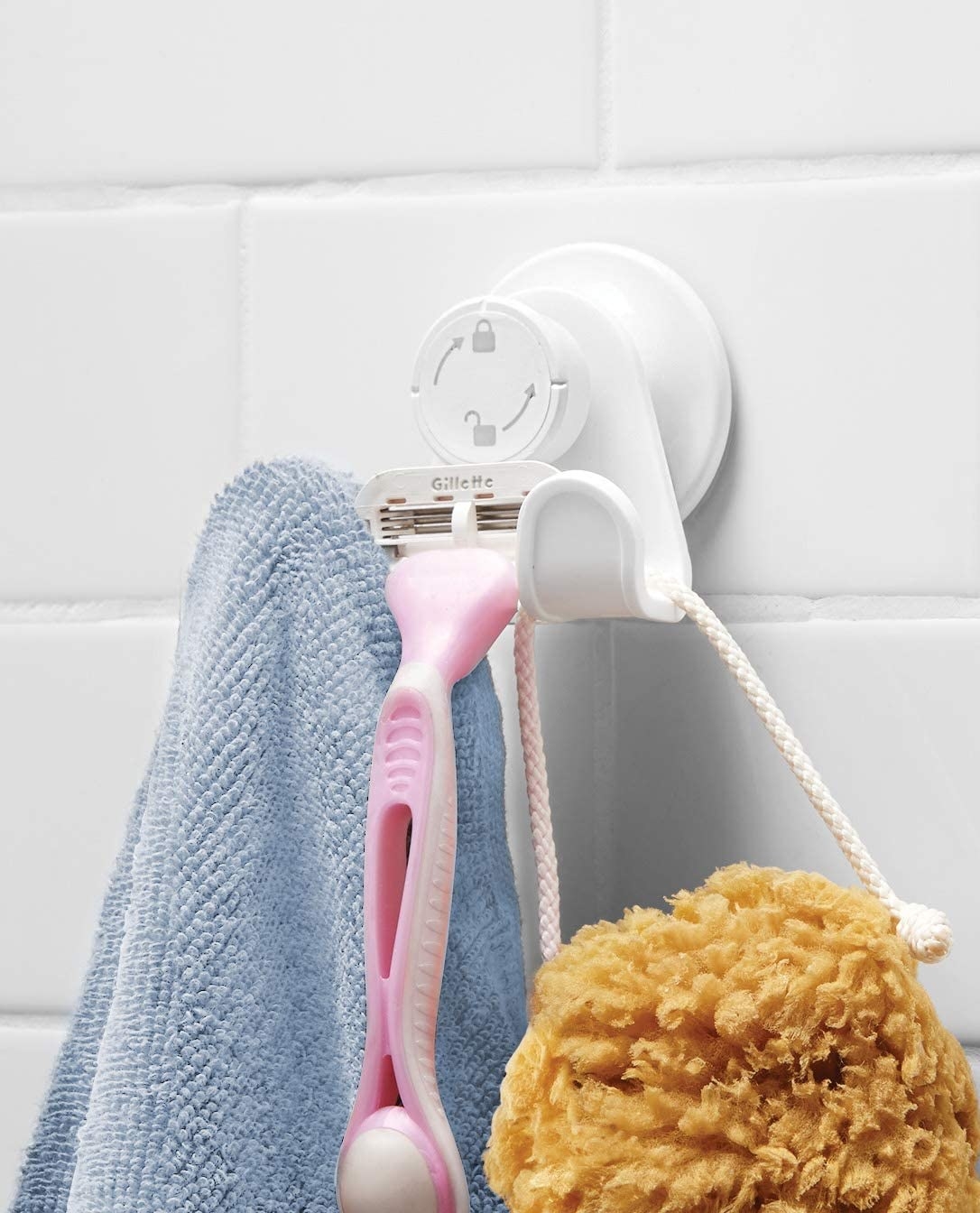 A double shower hook holding a washcloth, razor, and loofah