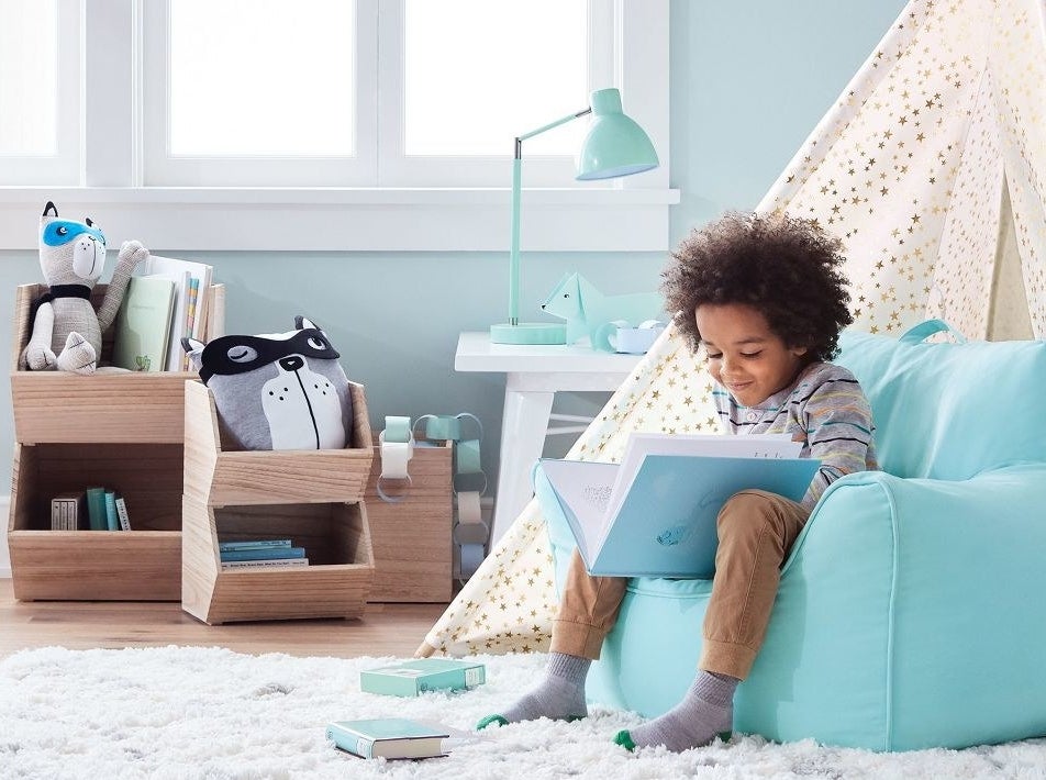 Model sitting beside wood shelves in playroom