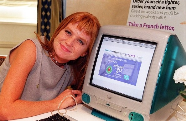 red haired young woman with head on a computer