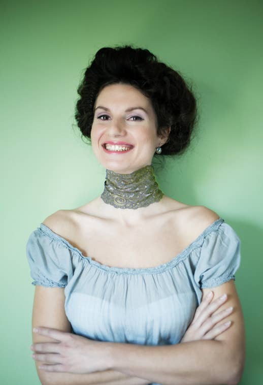 A woman smiling with a thick green choker