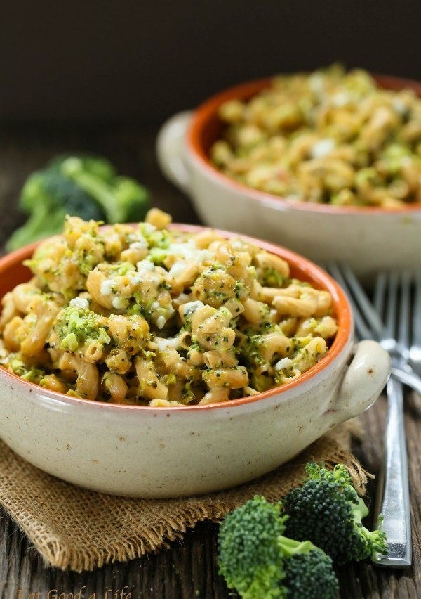 Two bowls of mac &#x27;n&#x27; cheese with tiny pieces of broccoli mixed in.