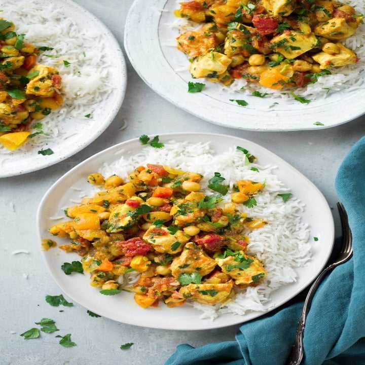 Three plates of chicken and chickpea tagine with white rice.