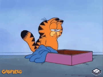 A gif of Garfield plopping into his bed, tired