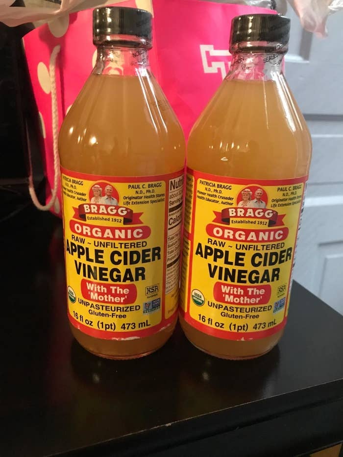 Two bottles of apple cider vinegar with red and yellow labels