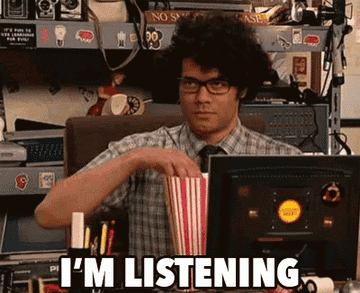 GIF of a man eating popcorn and saying &quot;I&#x27;m listening&quot;