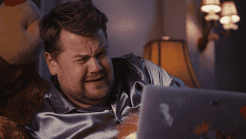 James Corden watching something on his laptop and crying