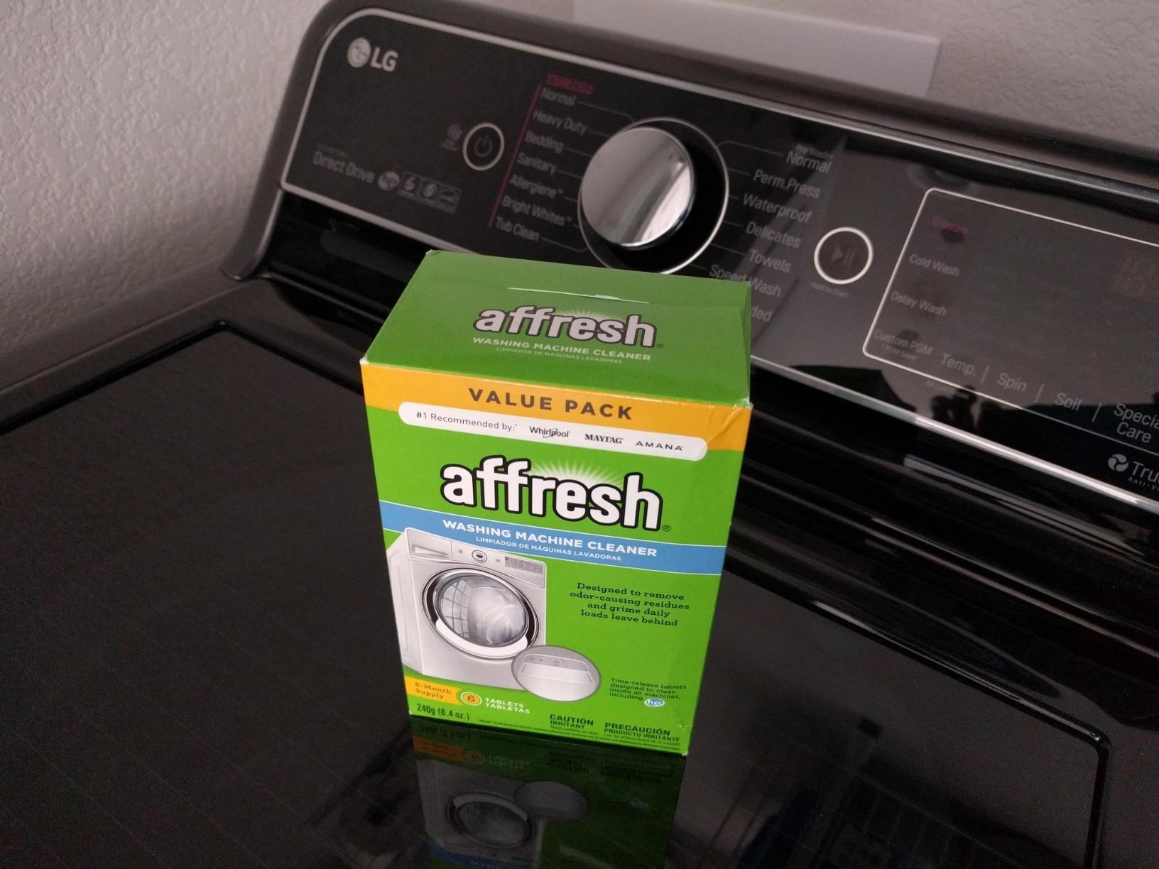 Reviewer&#x27;s photo of a green box of Affresh atop a washing machine