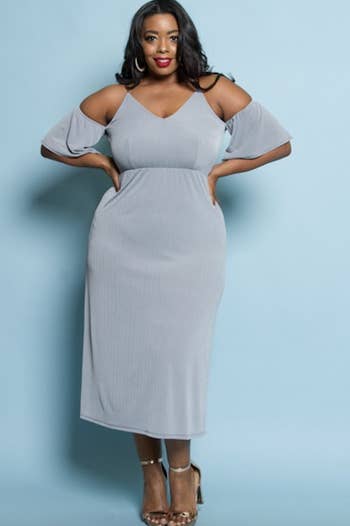 A model in a pale blue midi dress with cut out sleeves 