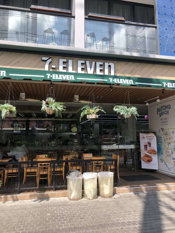 A fancy 7-11 store in Thailand with outdoor seating and plants