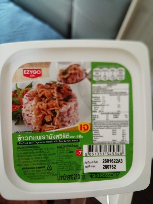 A packaged microwaveable meal with a photo of rice and basil vegetarian stir-fry