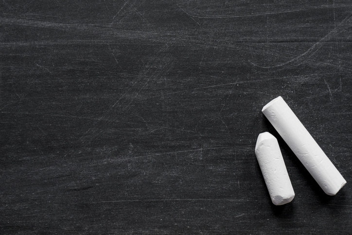 two pieces of chalk lie on a blackboard