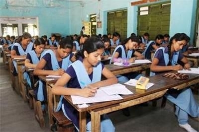 Female students in a classroom appear for an examination