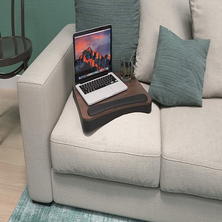 The memory foam desk with a laptop on top of it propped up on a couch 
