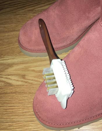 Reviewer's photo of shoe brush with brown handle and  white bristle along with metal bristles
