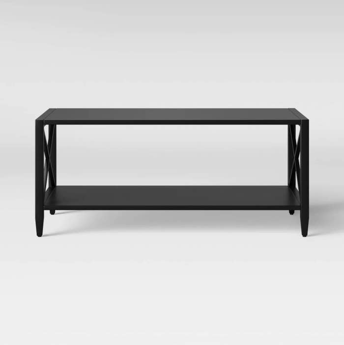 A black metal coffee table with cross beam designs on the side