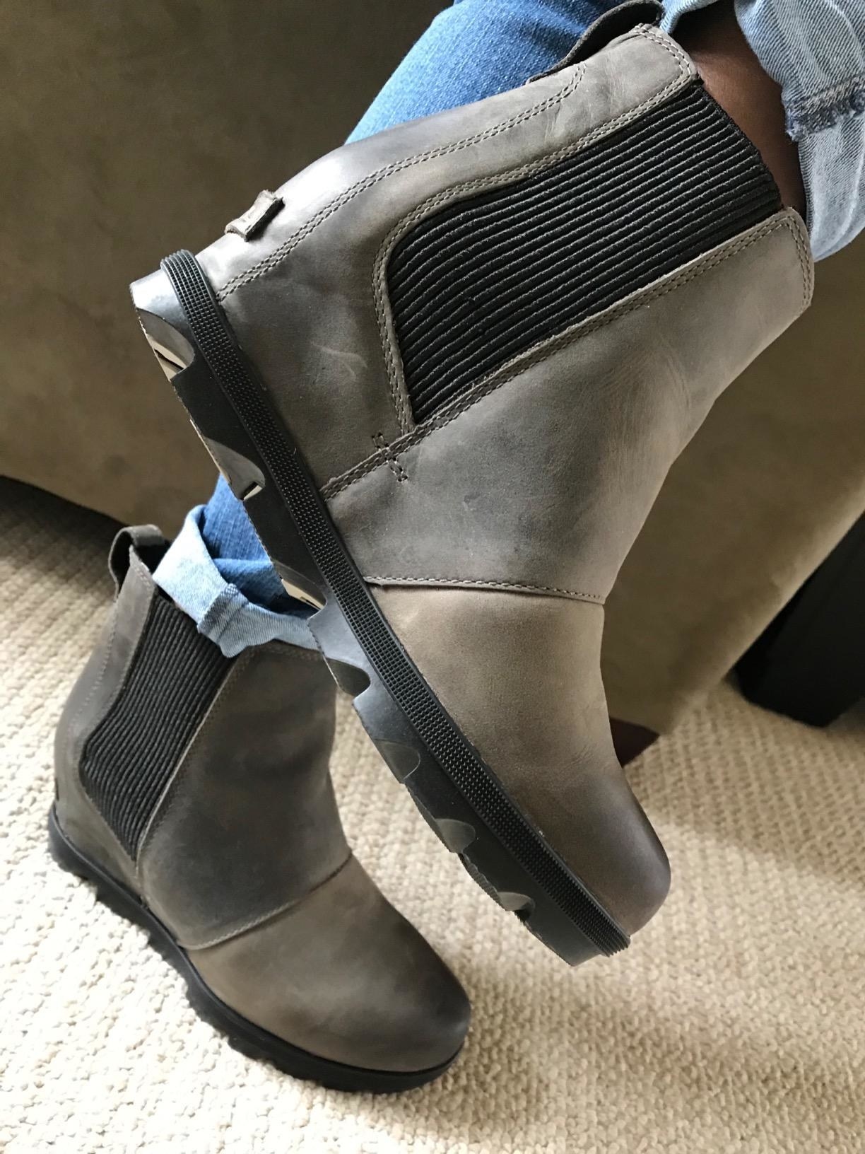 Reviewer wearing the wedge boots with wavy black sole with wide elastic section on either side