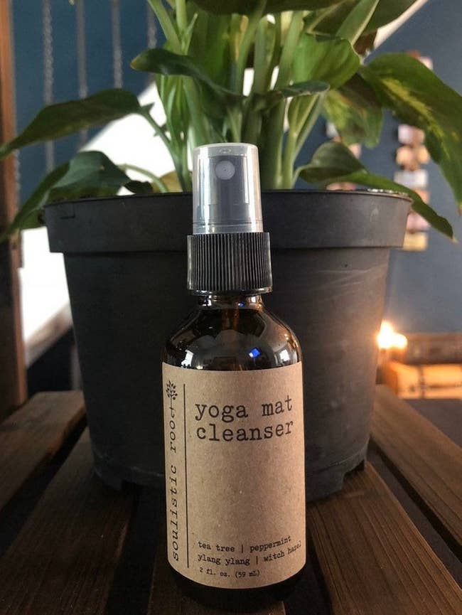 Brown spray bottle of yoga mat cleanser with a brown paper label