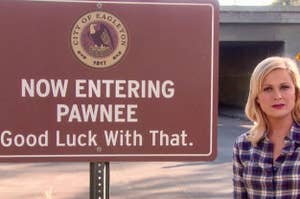 Leslie Knope next to a Now Entering Pawnee sign that says "Good luck with that."
