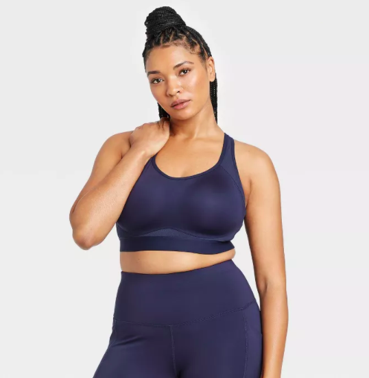 Model wears navy blue convertible sports bra with matching leggings