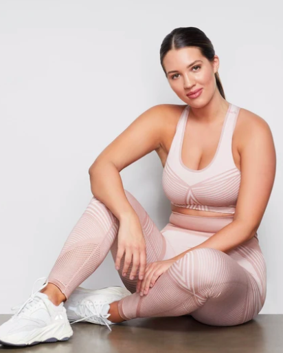 Model wears seamless light pink panel leggings with a matching sports bra and white sneakers