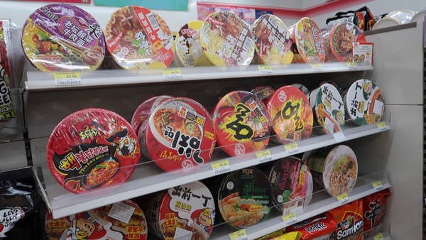 Three shelves full of instant noodle bowls