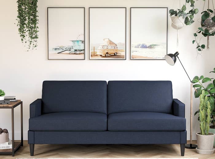 Blue sofa with rectangular arms and dark legs