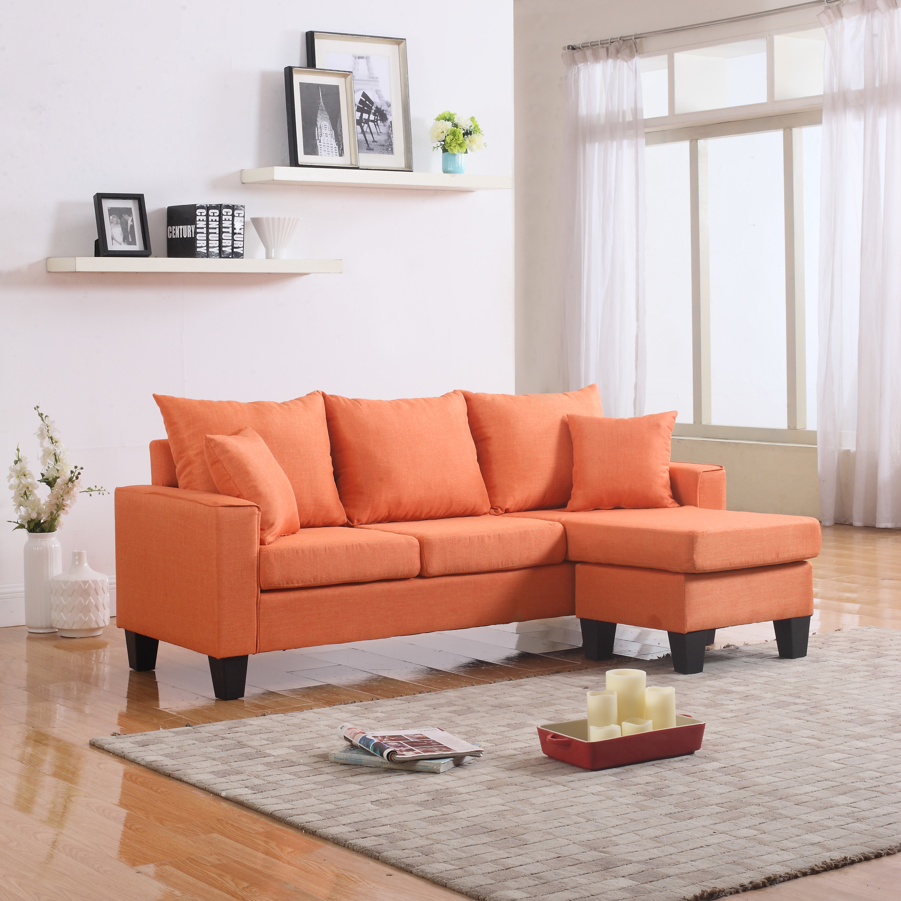 Orange couch with matching pillows and thick dark wooden legs