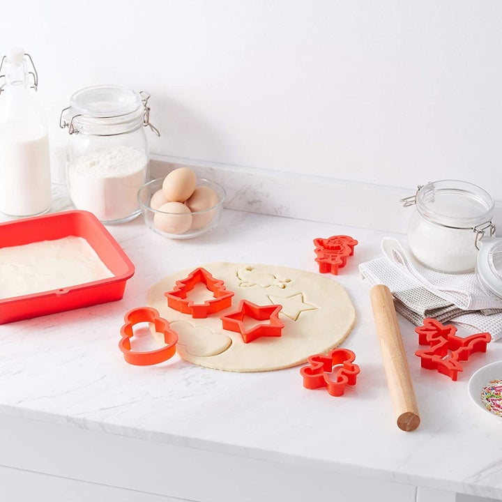 The mould and cookie cutters displayed on a kitchen counter with rolled out dough.