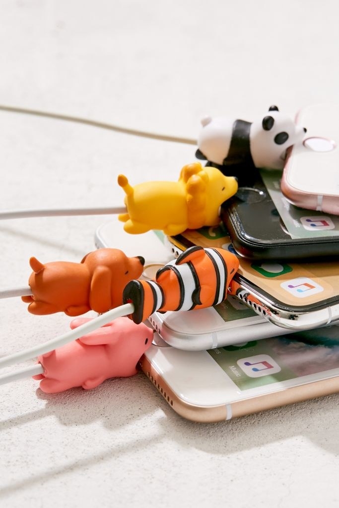 A panda, lion, clownfish, dog, and rabbit with their mouths open on cords attached to iPhones. 