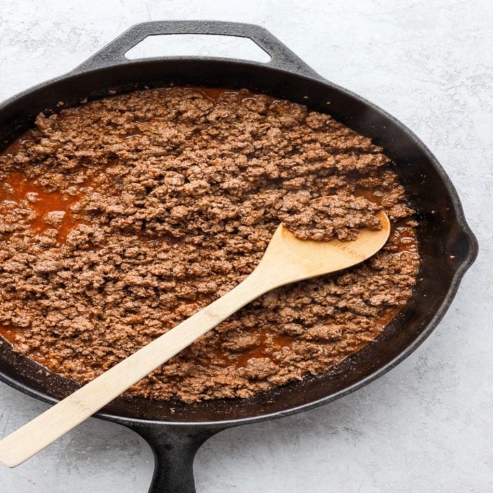 A skillet filled with cooked ground beef.