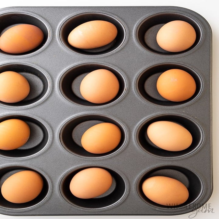 A dozen eggs in a muffin tin.