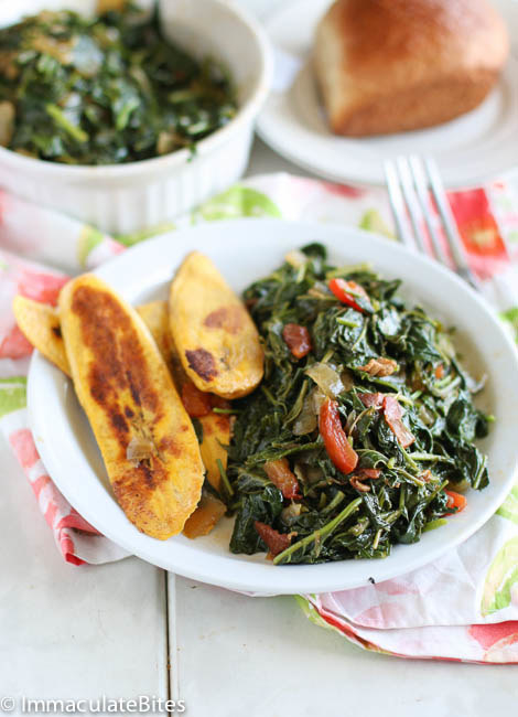 A plate of steamed leafy vegetables known as callaloo with a side of pan-fried plantains.