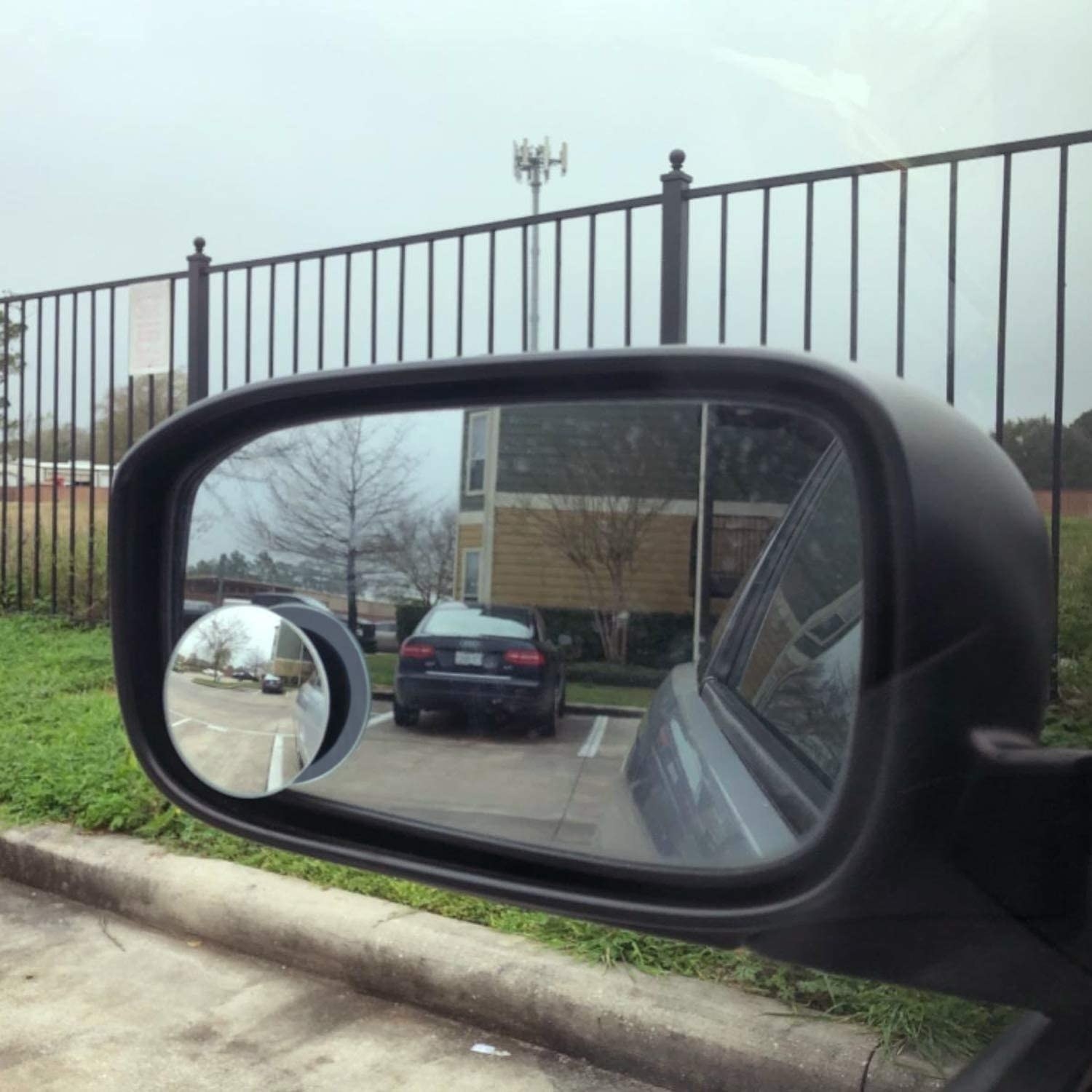 A car side mirror with the blindspot mirror attached, showing a better view of what&#x27;s behind the car