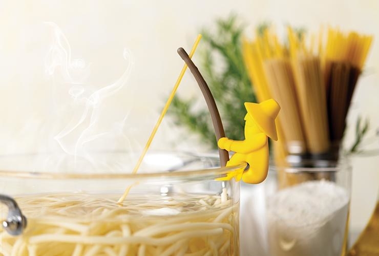 A small yellow man with a hat and brown stick that looks like a fishing pole holding one piece of spaghetti in it, attached to the edge of a pot filled with pasta. 