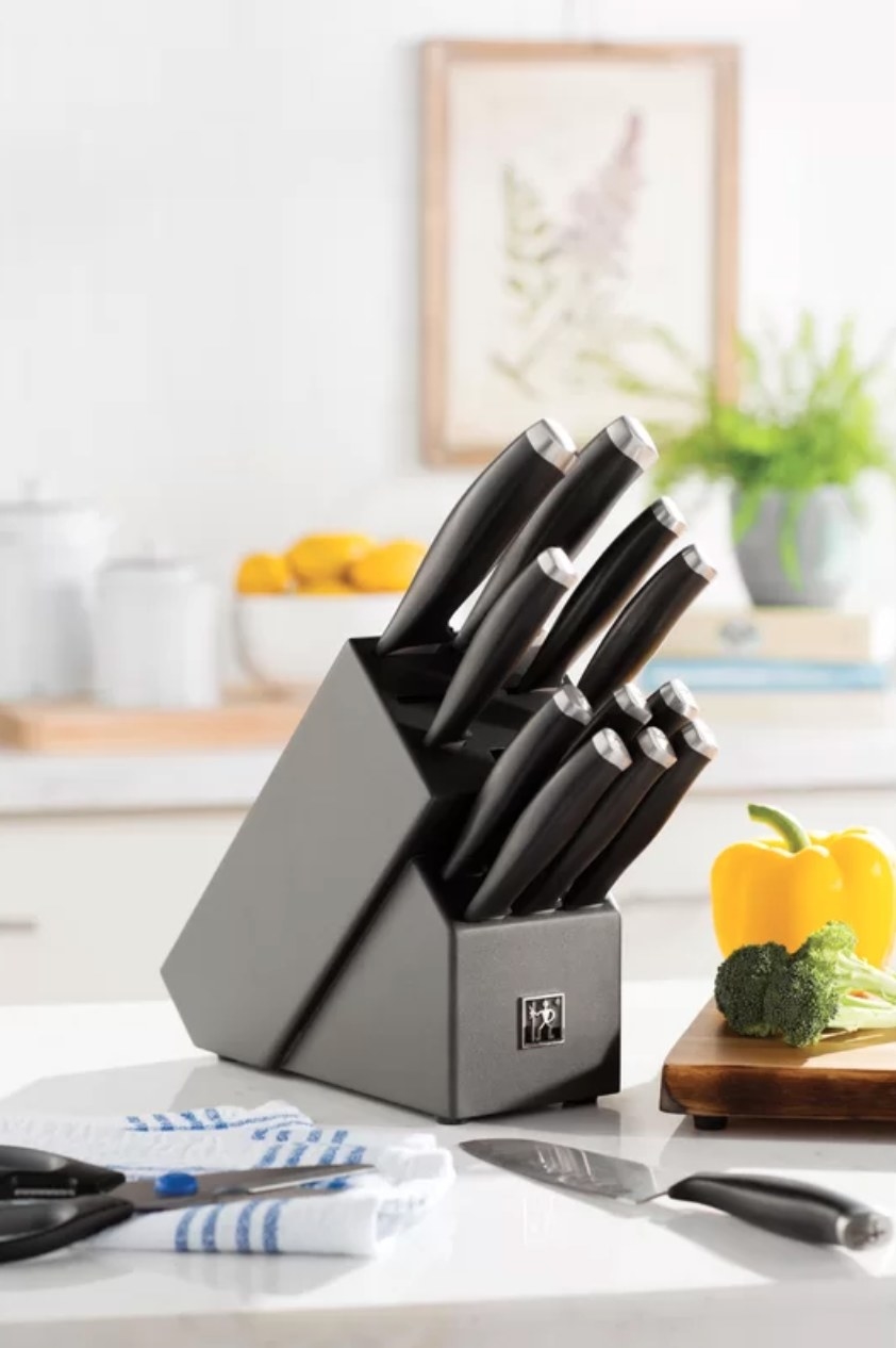 The knife block set next to a cutting board with vegetables