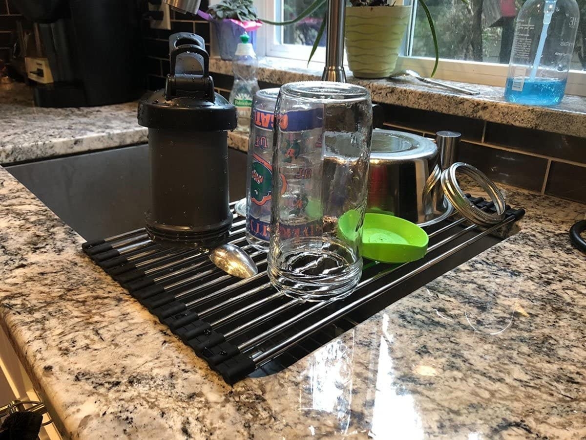 The drying rack unrolled over the sink, holding clean dishes
