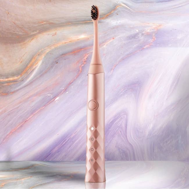 A rose gold electric toothbrush 