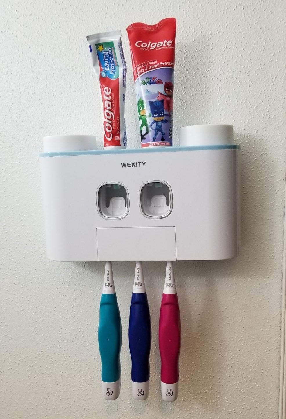 The toothpaste holder holding two tubes and three brushes