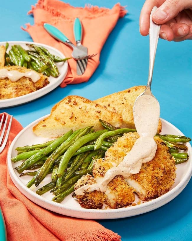 A plate of breaded chicken, green beans, and toast 
