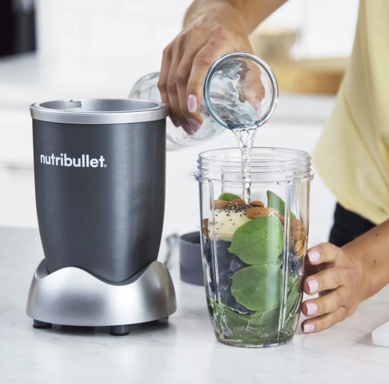 The Nutribullet being used to make a smoothie with greens and blueberries