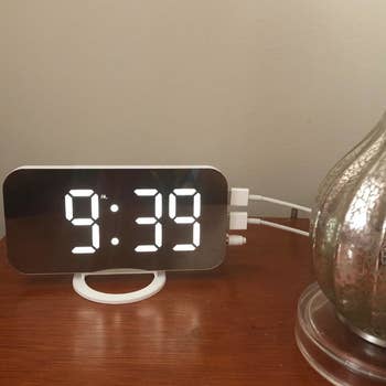 the alarm clock being used as a charging port on a reviewer's nightstand