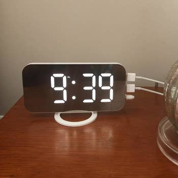 the alarm clock being used as a charging port on a reviewer's nightstand